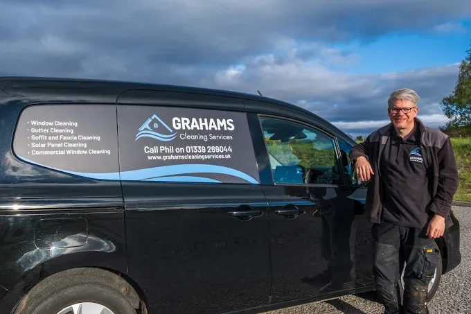 Phil Graham beside the black Grahams Cleaning Services van on Royal Deeside